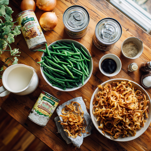 Ingredients for green bean casserole arranged on a wooden kitchen counter.