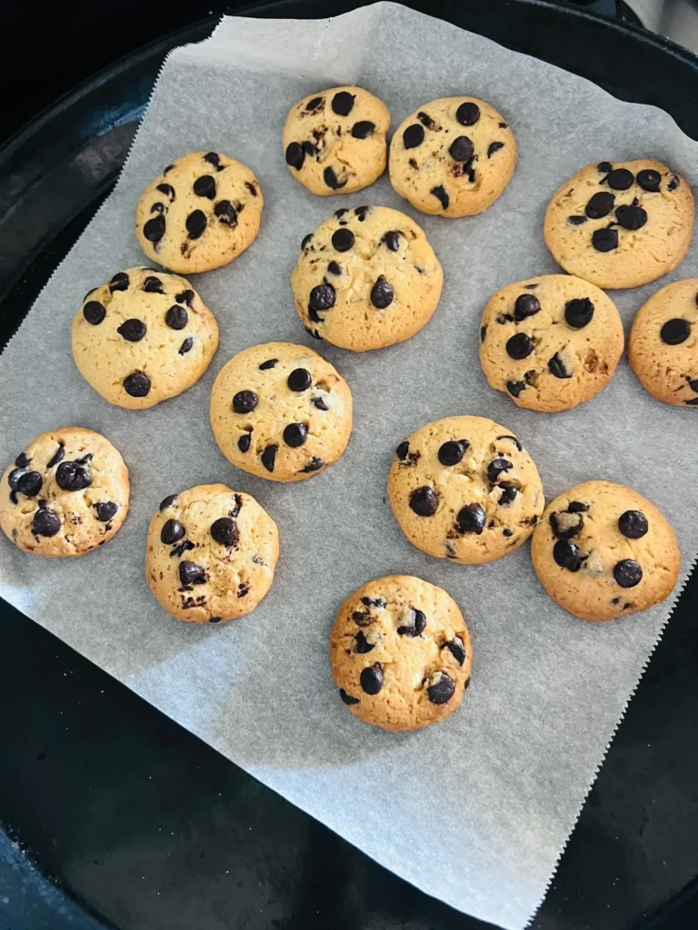 Soft and chewy chocolate chip cookies with golden edges on parchment paper