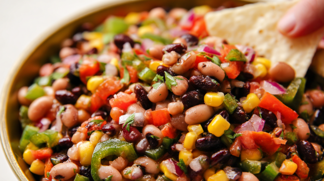 Cowboy Caviar colorful bean salad with black beans, corn, tomatoes, avocado, and lime dressing served as fresh dip