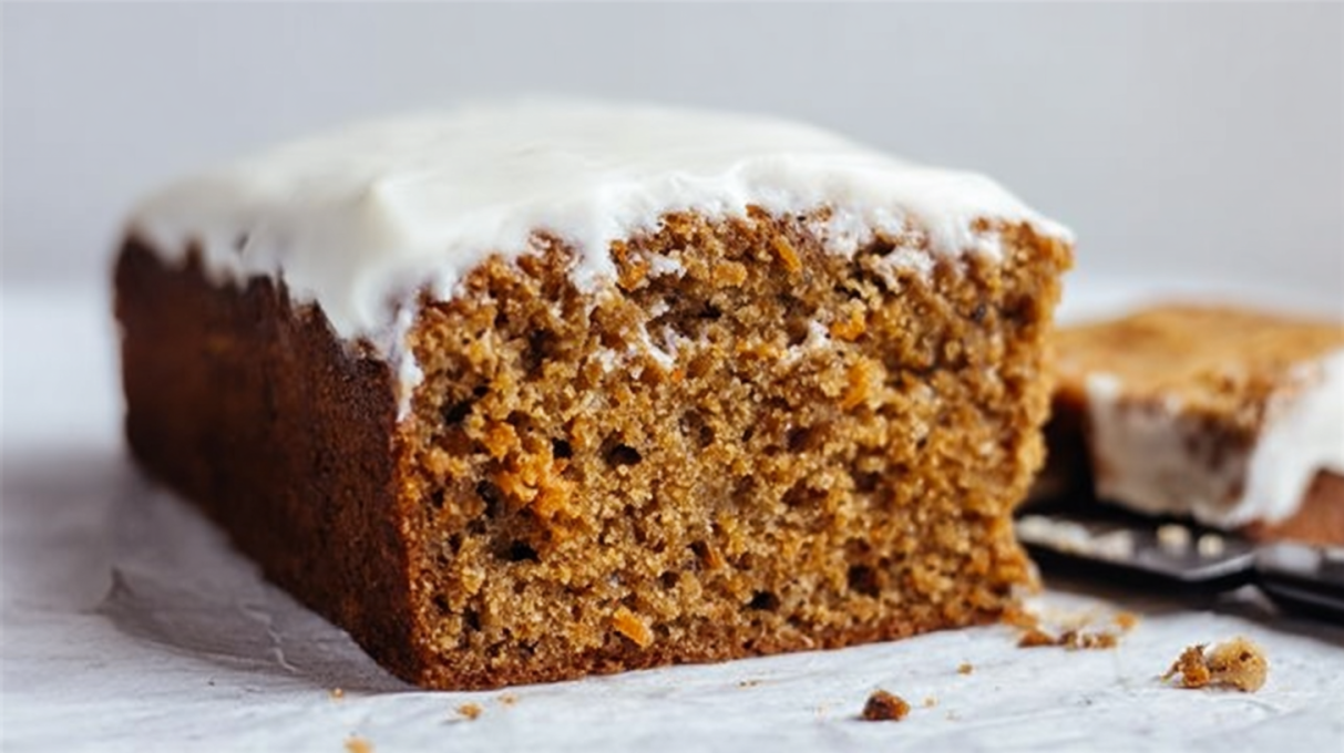 Sourdough carrot cake topped with creamy frosting and chopped walnuts, moist and spiced