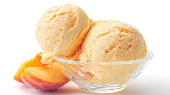 Peach ice cream with a creamy texture and chunks of fresh peaches served in a bowl