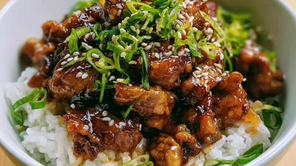 Honey garlic pork rice bowl topped with tender pork, fluffy rice, fresh vegetables, and a glossy honey garlic sauce.