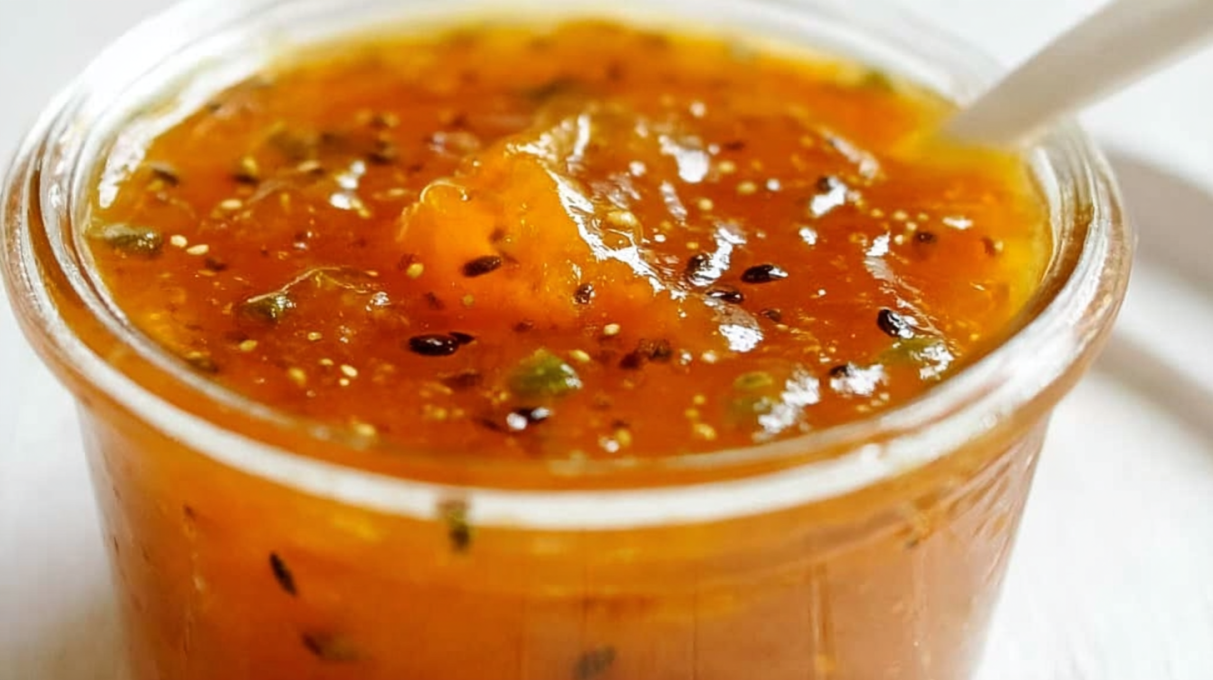 Homemade jalapeño apricot sauce in a glass jar, featuring a glossy sweet-and-spicy blend of apricots and jalapeños.