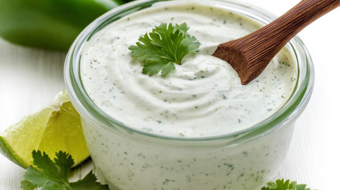 Creamy jalapeño ranch dressing served in a bowl, garnished with fresh jalapeño slices and herbs.
