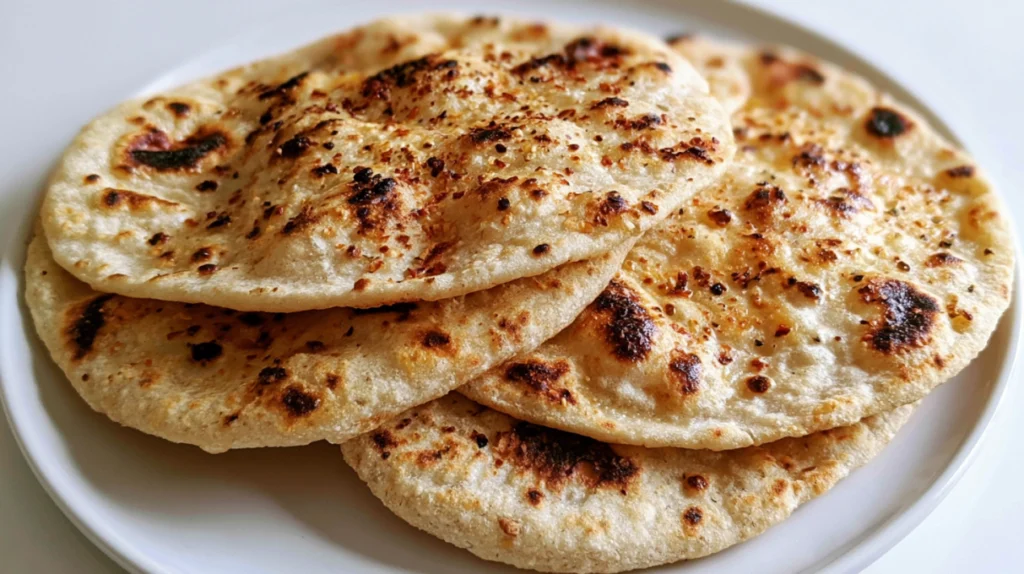 Sourdough flatbreads cooked until golden and lightly charred, stacked and ready to serve.