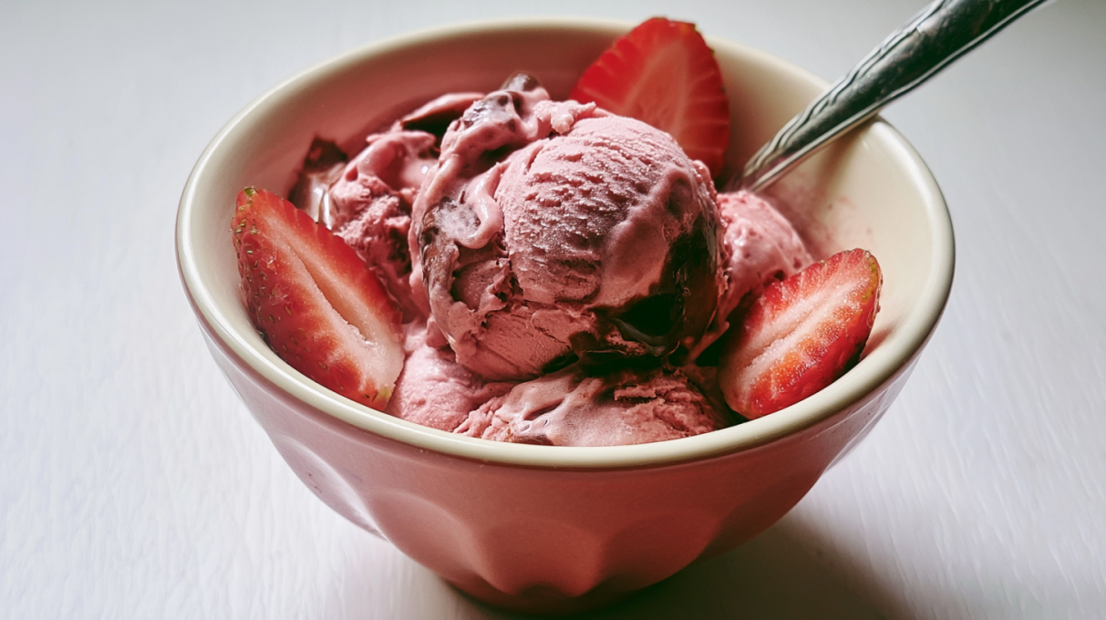 Strawberry banana chocolate ice cream served in a bowl with fresh strawberries, banana slices, and chocolate drizzle.