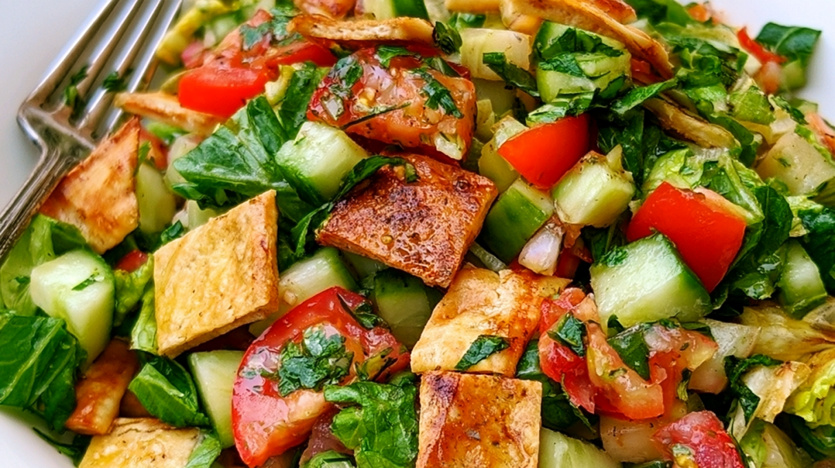 Fattoush salad made with crisp vegetables, toasted pita chips, fresh herbs, and a tangy sumac dressing.