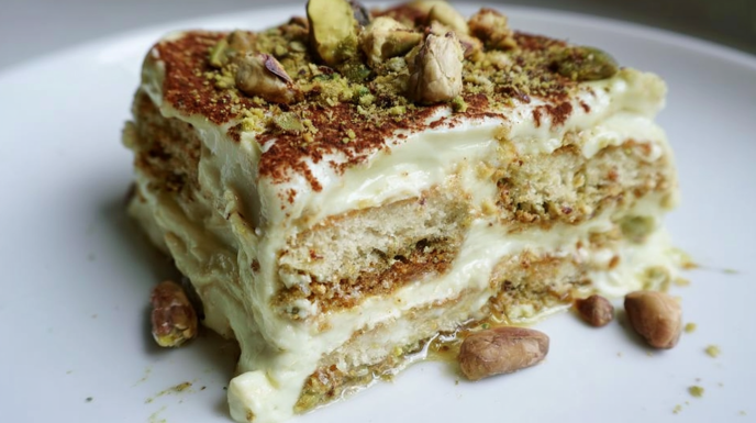 Pistachio tiramisu layered with creamy mascarpone, pistachio cream, and ladyfingers, topped with chopped pistachios.